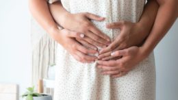 Early pregnancy symptoms - a man holding his hands on a woman's belly
