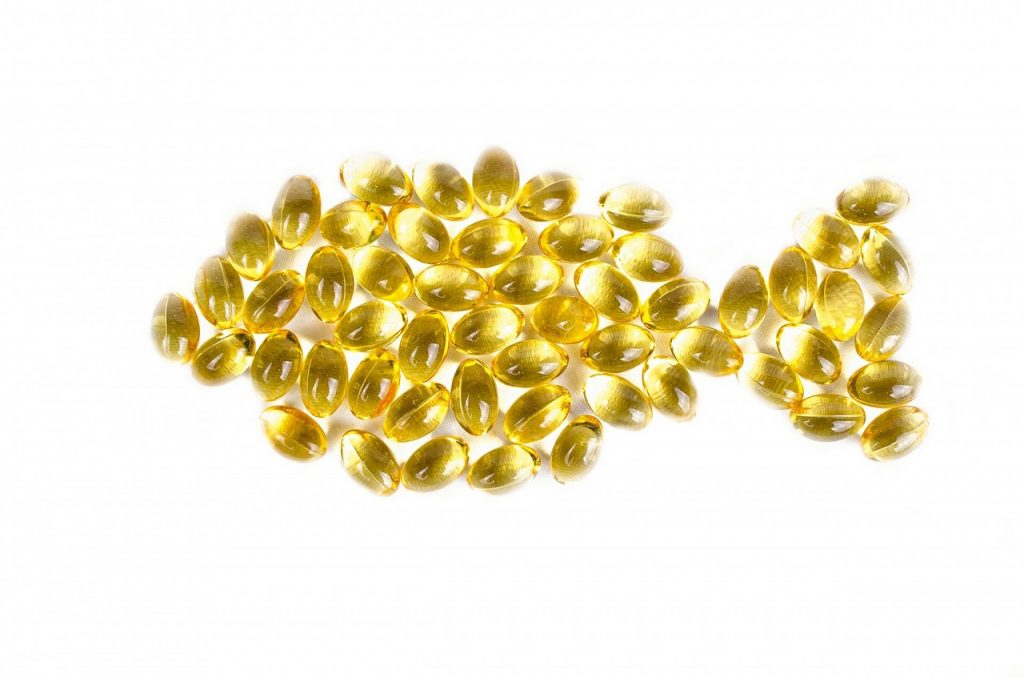Best supplements for pregnancy - Omega 3 and DHA pills forming shape of a fish.
